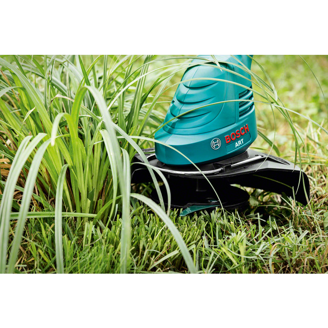Grästrimmer med Bosch-logotyp klipper gräs.