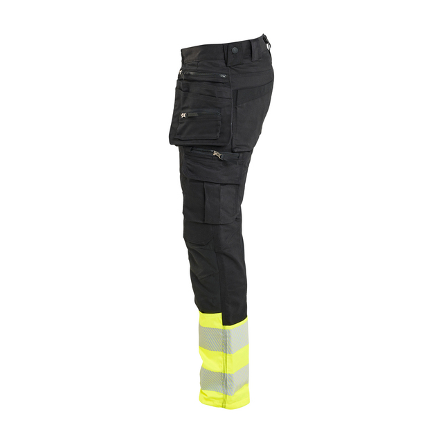 Svarta arbetsbyxor med gula reflexband vid anklarna och flera fickor.