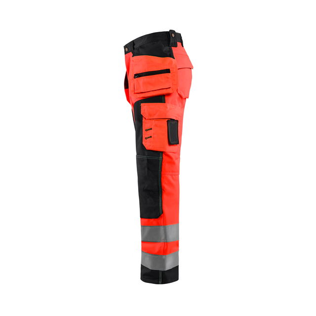 Arbetsbyxor i rött och svart med reflexband och flera fickor.