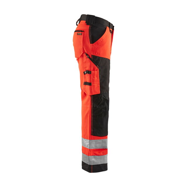 Arbetsbyxa i orange och svart med fickor och reflexband vid benen.
