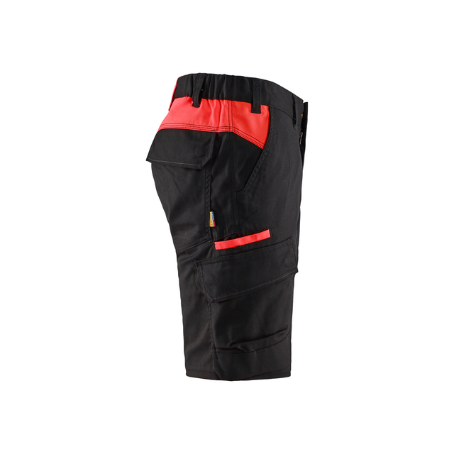 Svarta shorts med röda detaljer och flera fickor, sedd från sidan.