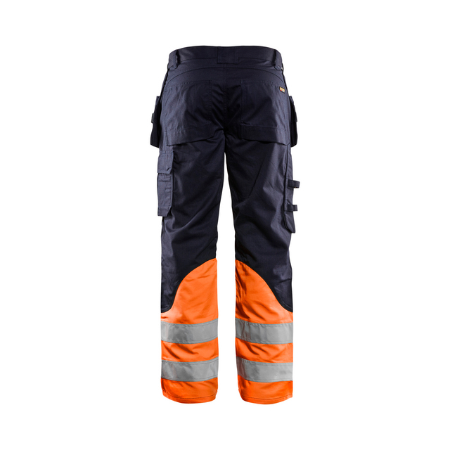 Arbetsbyxor i mörkt material med orange ben och reflexband, sedd bakifrån.