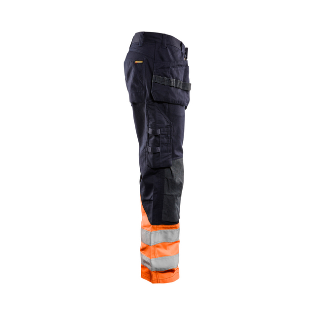 Mörka arbetsbyxor med orange och reflexband vid benen, flera fickor och en sidoficka med lock.