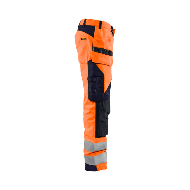 Orange och svarta arbetsbyxor med reflexdetaljer och flera fickor i varierande storlek.