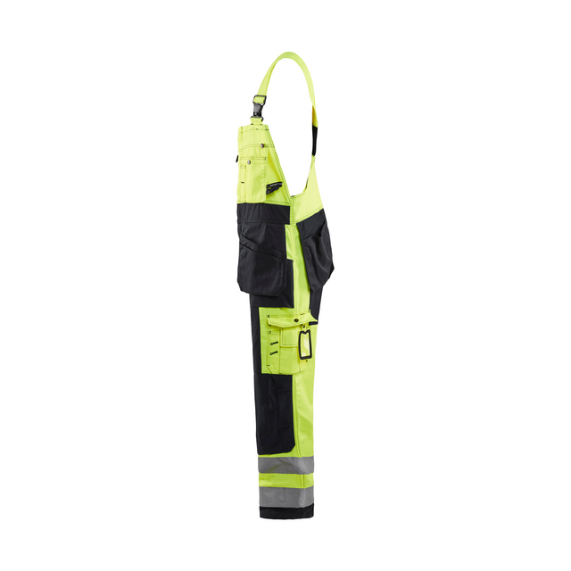 Arbetsbyxa i gult och svart med reflexband, flera fickor och hängslen.