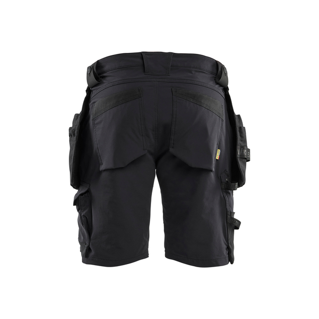 Svart arbetsbyxa i kort modell med flera fickor och förstärkningar, sedd bakifrån.