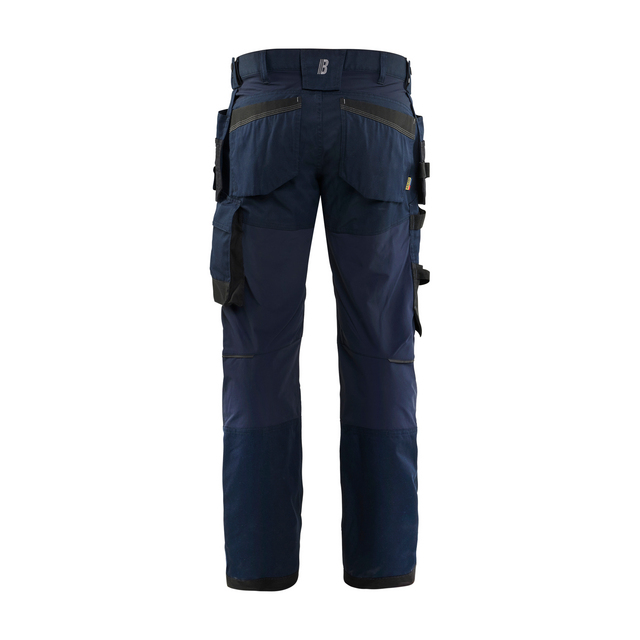 Blå arbetsbyxor bakifrån med flera fickor och förstärkta partier.