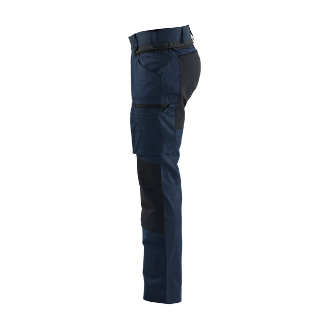 Blå och svarta arbetsbyxor med flera fickor, sedda från sidan.