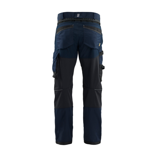 Byxor med flera fickor och förstärkta knän, sedda bakifrån, i mörkblått och svart tyg.