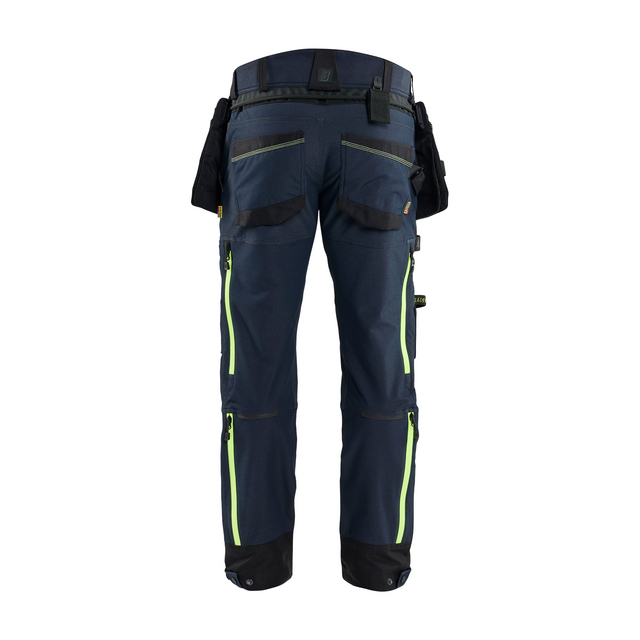 Mörkblå arbetsbyxor med gröna detaljer. Flera fickor och hylsor. Bakifrån.