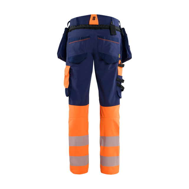 Arbetsbyxor i blått och orange, med reflexband på benen och flera fickor, sedd bakifrån.