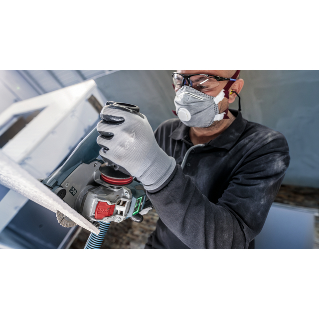 Person med skyddsglasögon och ansiktsmask använder en slipmaskin på metallplåt.