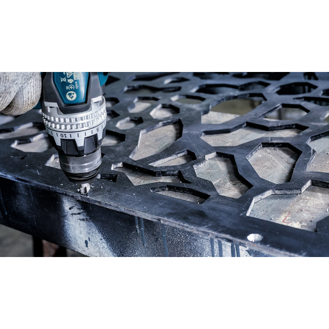 Borr med metallborr används för att bearbeta en detaljerad, geometrisk metallplatta.