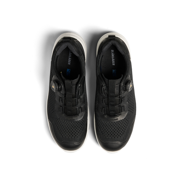 Svarta sneakers med ventilationshål och vit sula, sedd ovanifrån. Text på innersulan: DriWalk Air.